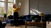 Woman adjusting crystal prism near sunny window