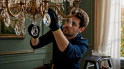 Lighting professional installing hanging crystal on chandelier