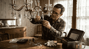 Man replacing chandelier crystal with pliers