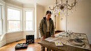 Home renovator examines chandelier parts in dining room