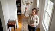 Homeowner adjusts crystal prism on chandelier