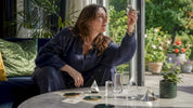 Woman arranging crystal prisms on wooden table