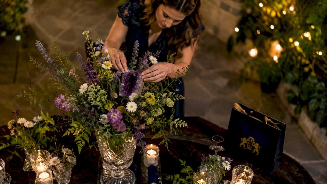 Florist arranging crystal centerpiece on banquet table