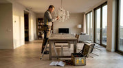 Electrician installs custom chandelier in city apartment