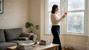 Woman adjusts crystals in sunny living room