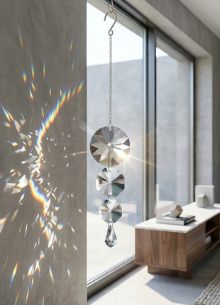 Decorative hanging crystal with rainbow effect on a wall in a modern room.