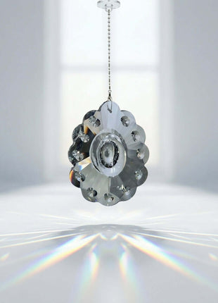 Metallic gear-like object hanging against a white background