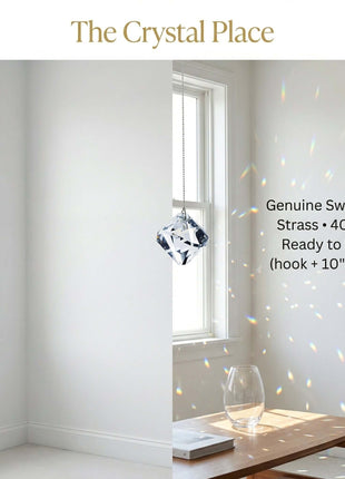 Swarovski Crystal decoration hanging in a room with windows and a table.