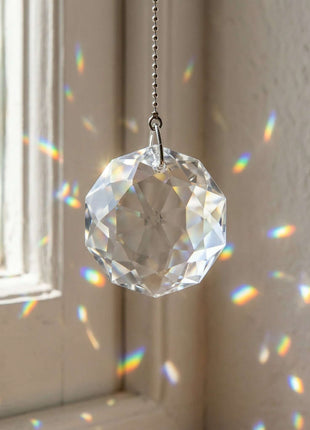 Swarovski Crystal prisms hanging in front of a window with rainbow