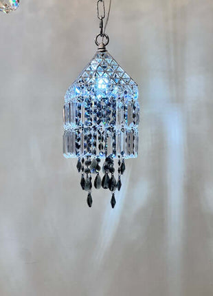 Crystal chandelier hanging against a neutral background by crystalplace.com
