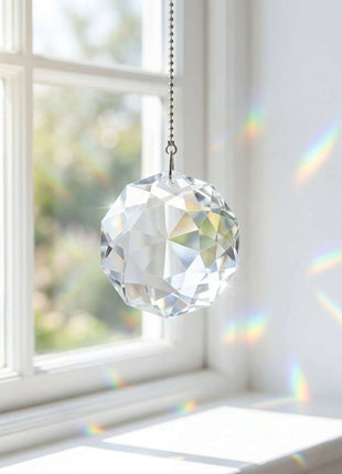 Swarovski Crystal hanging ornament in front of a window with rainbow