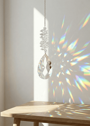 Crystal chandelier hanging above a wooden table with rainbow