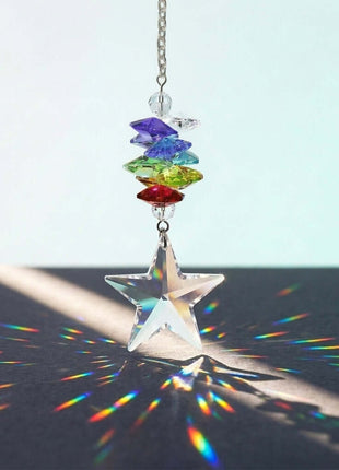 Colorful Swarovski crystal star-shaped hanging ornament with rainbow on a black surface.