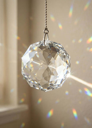 Swarovski Crystal prisms hanging from a chain with rainbow on a neutral background