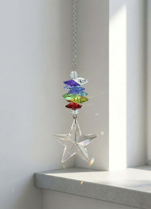 Swarovski Crystal star hanging ornament with colorful beads on a white windowsill.