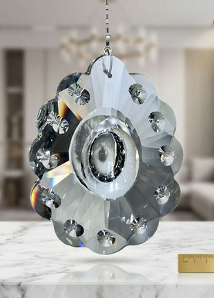 Decorative crystal pendant on a marble surface with a blurred indoor background