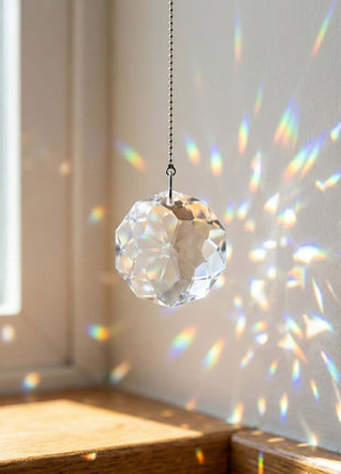 Swarovski Crystal prisms hanging from a chain, casting rainbow patterns on a wall.