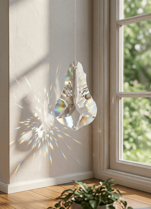 Crystal decoration hanging by a window with sunlight casting a rainbow effect