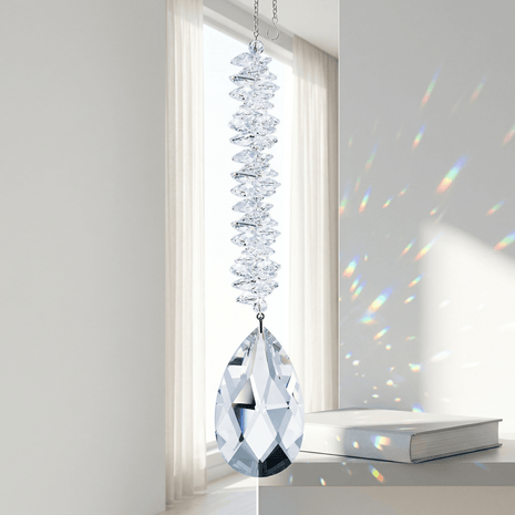 Crystal hanging ornament with rainbow effect on a plain background