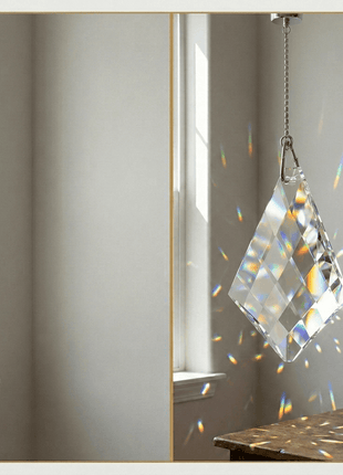 Crystal prism hanging in a room with a window and wooden surface.
