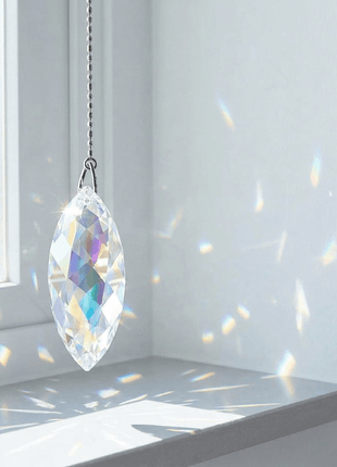 Swarovski Crystal hanging ornament casting rainbow colors on a white wall