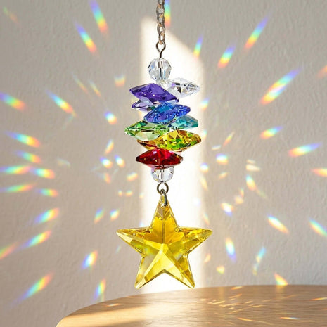 Colorful Swarovski crystal hanging ornament with star design, casting rainbow patterns on a light background.