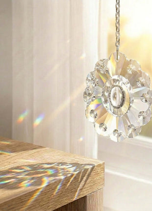 Crystal pendant light hanging above a wooden surface with soft lighting in the background.