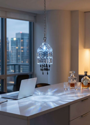 Modern kitchen island with laptop, glasses, and bottles under a crystal pendant light. by crystalplace.com
