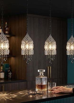 Crystal pendant lights hanging above a bar with bottles and glasses by crystalplace.com